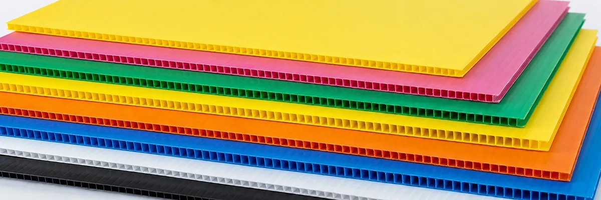 Stack of VELPLASTIC corrugated polypropylene sheets in yellow, pink, green, orange, blue, white and black
